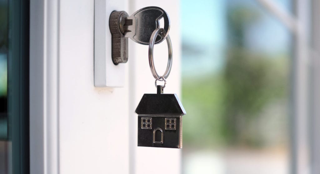 The house key for unlocking a new house is plugged into the door.